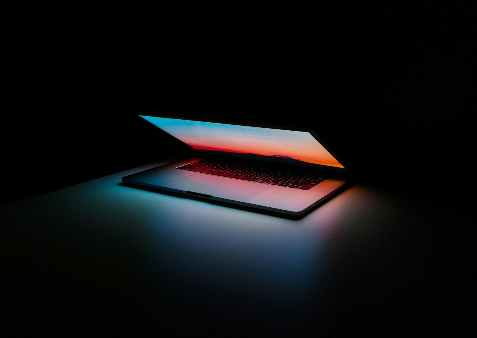 Open laptop on a desk in low light